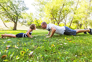 A Father And Daughter Staring Each Other Down In A Park During A Family Outing, Edmonton, Alberta, Canada