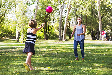 Mother And Daughter Throwing A Ball In A Park During A Family Outing, Edmonton, Alberta, Canada