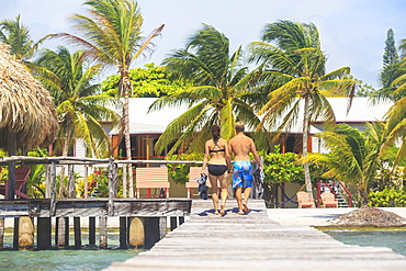 A Couple Walking On A Wooden Dock, Saint Georges Caye Resort, Belize City, Belize