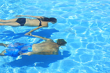 A Couple Swimming Underwater In A Pool, Saint Georges Caye Resort, Belize City, Belize