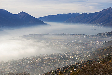 Fog Sets In Over A City And Alpine Lake, Locarno, Ticino, Switzerland