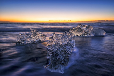 Waves Break Around Icebergs On The Southern Shore Of Iceland, Near The Glacial Lagoon Of Jokursarlon, Iceland