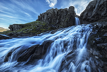 A Small Waterfall Flows Into The Ocean Along The Eastern Coast Of Iceland, Iceland