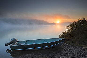 The Sun Rises Through Fog Over The Kvichak River In Autumn With A Skiff In The Foreground, Bristol Bay Region, Southwest Alaska.