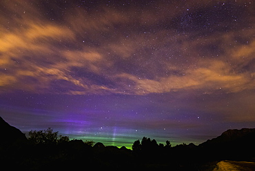 Stars And The Northern Lights (Aurora Borealis) Shine Through High Clouds Over Pitt Lake, British Columbia, Canada