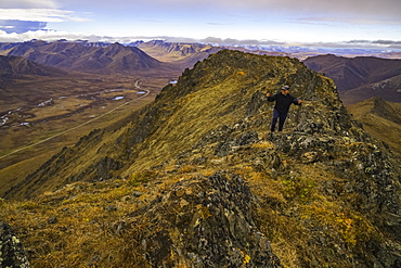 Man Hiking On A Lookout Overlooking The Blackstone Valley, Along The Dempster Highway, Yukon, Canada