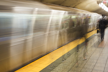 Motion Blur Of Passengers Walking On The Platform Beside The Moving Subway, New York City, New York, United States Of America