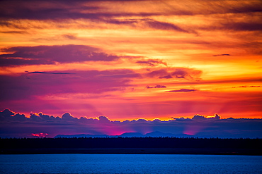 Light Shines From Behind Clouds And Mountains At Sunset, Anchorage, Alaska, United States Of America