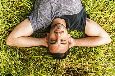 Close Up Of A Man Laying On The Grass With His Hands Behind His Head, Reigate, England