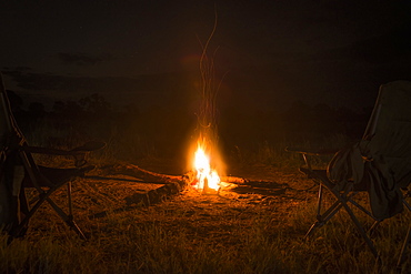 Two Camp Chairs Around Fire At Night, Botswana