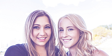 Two Girlfriends Posing For The Camera In A Downtown City Park, Edmonton, Alberta, Canada