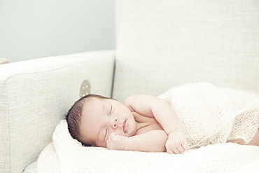 Newborn Baby Girl Asleep On Rocking Chair With Hand Nestled Up Near Face, Toronto, Ontario, Canada