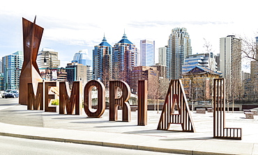 A sign spelled in lettering for Memorial Drive with the Calgary skyline in the background, Calgary, Alberta, Canada