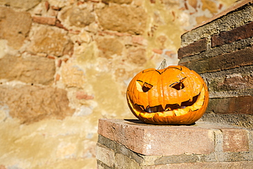 Close-Up Of A Homemade Carved Halloween Pumpkin On A Stone Wall, Pienza, Italy