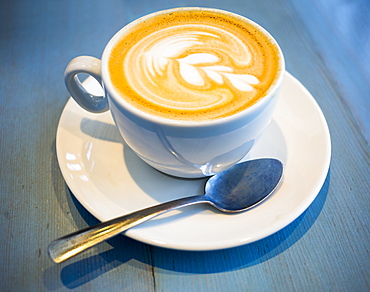 Cup Of Frothy Chai Tea Latte On A Blue Countertop, Vancouver, British Columbia, Canada