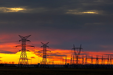 Silhouette Of Large Metal Electrical Towers At Sunset With A Colourful Sky In The Background, Calgary, Alberta, Canada