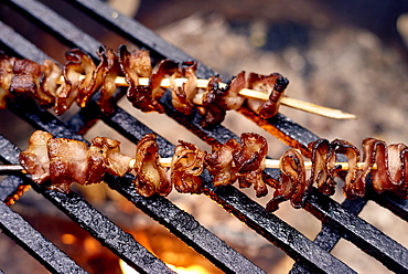 Bacon Skewers Cooking Over A Flame On A Grill, Ontario, Canada