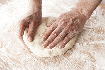 Hands Working With Pizza Dough On A Wooden Floured Surface