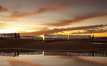 Fence Reflecting In The Water At Sunset