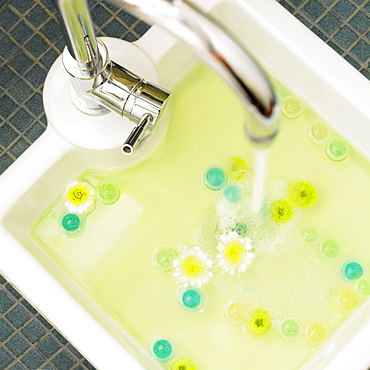 Pedicure Sink With White And Yellow Flowers And Teal Bath Beads Floating In Water, Victoria British Columbia, Canada