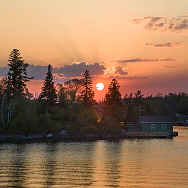 Cottage On The Edge Of A Lake At Sunrise With A Pink Sky, Lake Of The Woods, Kenora, Ontario, Canada