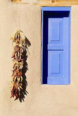 Blue Window And Chili Peppers Hanging On Wall, Taos, New Mexico, Usa