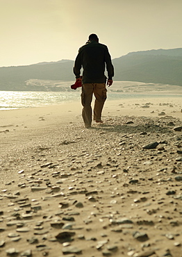 Man Walking On A Rocky Beach