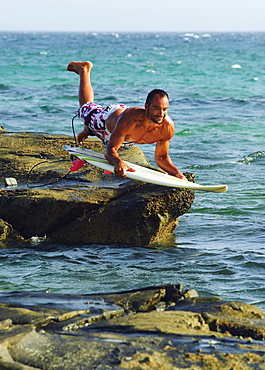 Man Jumping Into The Water On His Surf Board