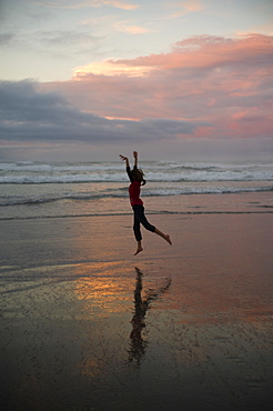 A Girl Dances On The Beach At Sunset, Waihi Beach, New Zealand