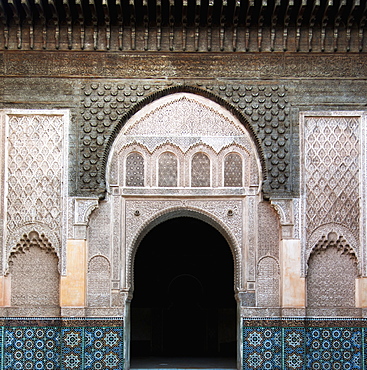 An arched doorway on a building with ornate facade and colourful tile