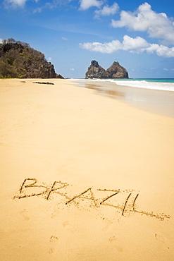 View of morro dos irmaos from praia do bode with brazil written in the sand, Fernando de noronha pernambuco brazil