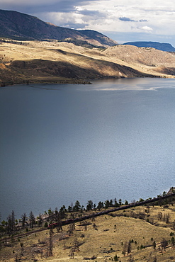 A small train makes it's way along the shore of kamloops lake, Kamloops, british columbia, canada