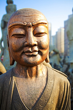 Bronze faced buddha statue glowing in warm light, Beijing china