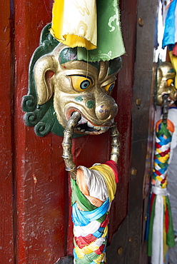 An ornate doorknob in animal likeness with colourful fabric tied to it, Lhasa xizang china