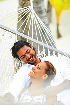 A man and woman in a hammock at the bora bora nui resort and spa, Bora bora island society islands french polynesia south pacific