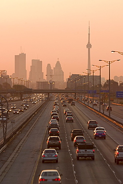 View Of Toronto Skyline From Above Queen Elizabeth Way Highway During Start Of Rush Hour Traffic, Toronto, Ontario, Canada.