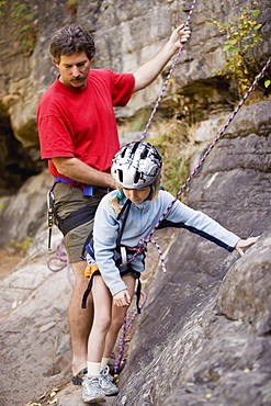 Young Girl (Age 7) Preparing To Climb While Father Belays At Stone Hills Near Rexford, Montana, Usa