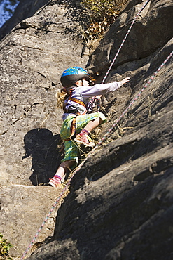 Young Girl (Age 5) Climbing On Granite Cliff At Stone Hills Near Rexford, Montana, Usa