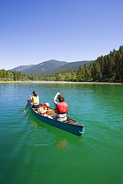 Young Family Canoeing On Loon Lake In The East Kootenays, British Columbia, Canada