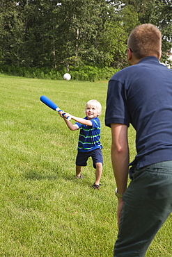 A Father Plays Baseball With His Young Son In The Park, Stony Plain, Alberta, Canada