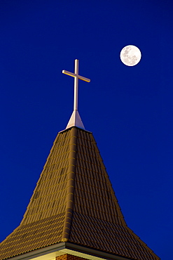 Close Up Of Church Steeple With Cross At Night With Full Moon In A Deep Blue Sky, Calgary, Alberta, Canada