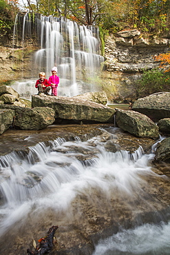 Brother And Sister Pose In Front Of A Waterfall In Rock Glen Conservation Area, Ontario, Canada