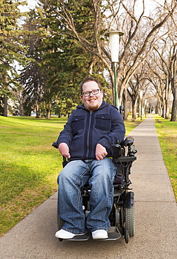 Disabled Man Using His Powered Wheelchair In A Park In Autumn, Edmonton, Alberta, Canada