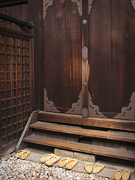 Japanese Shrine With Wooden Door And Slippers On Rock Steps, Kyoto, Japan