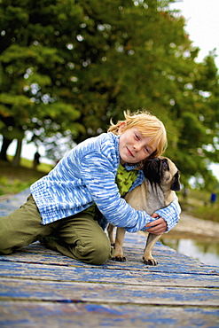 Girl Hugging A Dog On A Dock, Picton, Ontario, Canada