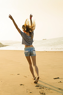 Young Woman Listening To Music With Her Headphones On The Beach, Xiamen, China