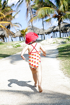 Child Running Down A Path Barefoot Towards The Beach, Varadero, Cuba