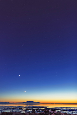 The Moon Rises Above Mount Susitna On A Clear Winter Night, Sea Ice Visible In The Foreground, Anchorage, Alaska, United States Of America