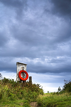 Red Ring Life Preserver Hanging On A Wooden Post, Northumberland, England