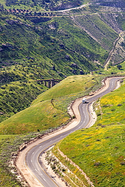 A Winding Road That Makes It's Way Up And And Around The Golan Heights, With Remains Of A Train Track Bridge Built Over The Yarmouk River In The Distance, Golan Heights, Israel